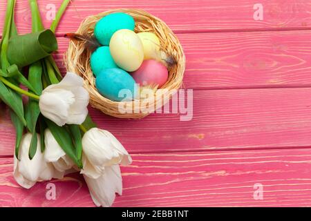 Pasqua, vacanze, la tradizione e il concetto di oggetto - close up di uova colorate e tulip fiori su tavole di legno sfondo Foto Stock