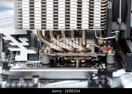 Immagine macro di una moderna scheda madre per sistemi desktop con un dissipatore di calore montato sulla CPU sul socket LGA. Foto Stock