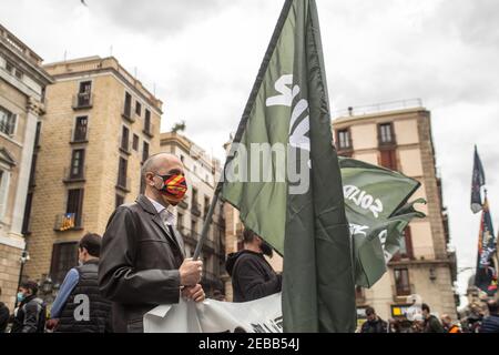 Barcellona, Catalogna, Spagna. 12 Feb 2021. Il protestore è visto con una bandiera che legge, solidarietà. L'associazione spagnola formata da agenti del corpo nazionale di polizia e della Guardia civile, Jusapol (polizia di giustizia) Ha convocato una concentrazione a Barcellona sostenendo che il governo ha abbandonato la polizia in Catalogna e chiede al governo di dichiarare la Catalogna come una speciale sicurezza per le aree. All'evento ha partecipato Ignacio Garriga, candidato del partito di estrema destra spagnolo Vox, per la presidenza della Generalitat di Catalogna. Gruppi antifascisti che hanno dimostrato contro Foto Stock