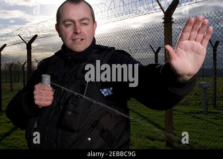 Responsabile della polizia del Regno Unito che utilizza spray inabilitante Foto Stock