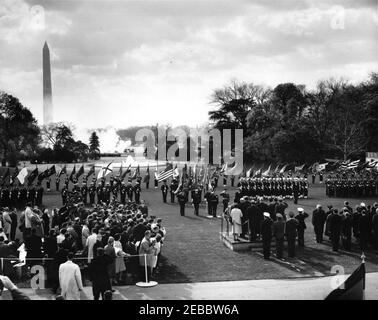 Cerimonie di arrivo per Konrad Adenauer, Cancelliere della Germania Occidentale, 10:45. Vista del prato meridionale durante le cerimonie di arrivo in onore del Cancelliere della Germania occidentale, il Dr. Konrad Adenauer; il Presidente John F. Kennedy, il Cancelliere Adenauer e altri dignitari si trovano sulla piattaforma di revisione a destra. Guardie militari d'onore e di colore sono all'attenzione. Anche nella foto: White House Secret Service Agent, Roy Kellerman e Bob Lilley. Il monumento di Washington è visibile in lontananza. White House, Washington, D.C. Foto Stock