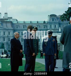 Cerimonia di arrivo per Abdirashid Ali Shermarke, primo Ministro della Repubblica somala, 11:45. Il presidente John F. Kennedy (di ritorno alla macchina fotografica) parla con il capo di stato maggiore dell'esercito degli Stati Uniti, il generale Earle G. Wheeler, durante le cerimonie di arrivo in onore del primo ministro della Repubblica somala, il Dott. Abdirashid Ali Shermarke. Da sinistra a destra: Vice Segretario di Stato degli Stati Uniti per gli Affari africani, Henry J. Tasca; Presidente Kennedy; Generale Wheeler; Air Force Aide al Presidente Kennedy, Generale Brigadier Godfrey T. McHugh. L'edificio dell'ufficio esecutivo è visibile sullo sfondo. South Lawn, Wh Foto Stock