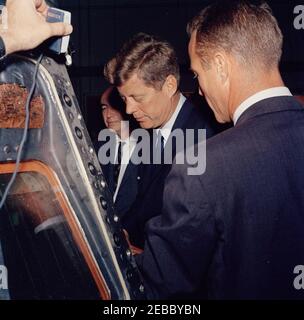 Visita delle installazioni della NASA: Houston, Texas, NASA Rich Building, partenza alle 11:10. Il presidente John F. Kennedy visita le mostre di veicoli spaziali all'interno di un hangar presso il Rich Building del presidiato Spacecraft Center, Houston, Texas; il comandante dell'astronauta tenente M. Scott Carpenter (torna alla fotocamera) slip il presidente Kennedy. Direttore del Centro Spacecraft con equipaggio, il Dr. Robert Gilruth (parzialmente in ombra), si trova dietro. Il presidente ha visitato il Centro come parte di un tour di due giorni delle installazioni sul campo della National Aeronautics and Space Administration (NASA). Foto Stock