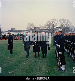 Cerimonia di arrivo per Jorge Alessandri Rodru00edguez, Presidente del Cile, 11:15. Il presidente John F. Kennedy e il presidente del Cile, Jorge Alessandri Rodru00edguez, hanno esaminato le truppe di guardia d'onore durante le cerimonie di arrivo in onore del presidente Alessandri Rodru00edguez. Comandante delle truppe, il colonnello John W. Gorn, cammina con i presidenti. South Lawn, White House, Washington, D.C. [i graffi su tutta l'immagine sono originali al negativo.] Foto Stock