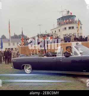 Viaggio in Europa: Germania, Hanau: Arrivo a Fliegerhorst Kaserne, indirizzo, e ispezione di truppe e attrezzature, 10:45. Il presidente John F. Kennedy (al centro) corre nella limousine presidenziale (Lincoln-Mercury Continental convertibile) con il comandante generale della terza Divisione corazzata, il generale maggiore John R. Pugh, durante la sua visita alla Kaserne di Fliegerhorst ad Hanau, Germania occidentale (Repubblica federale). Anche nella foto: Ispettore generale della Bundeswehr, Friedrich A. Foertsch; cognata del presidente Kennedyu0027s, principessa Lee Radziwill della Polonia; Ministro federale della difesa della Germania occidentale, Kai-U. Foto Stock