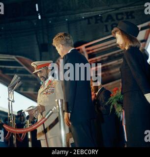 Cerimonia di arrivo per Haile Selassie i, imperatore d'Etiopia, 12:00 PM. L'Imperatore d'Etiopia, Haile Selassie i, commenta durante una cerimonia di arrivo in suo onore; osserva il presidente John F. Kennedy. First Lady Jacqueline Kennedy si trova all'estrema destra; capo della sezione politica del gabinetto privato dell'imperatore Selassieu2019, Dr. Menassie Haile, si trova a destra (parzialmente nascosto dietro il presidente Kennedy). Union Station, Washington, D.C. Foto Stock