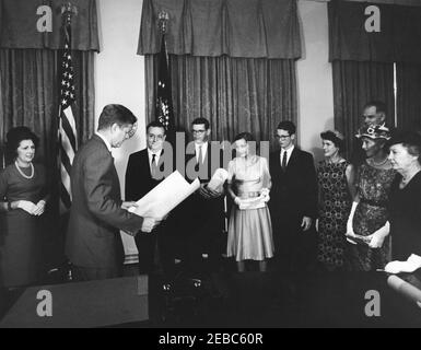 Cerimonia di giuramento, James Ramey u0026 John Palfrey, membri della Commissione per l'energia atomica (AEC), 12:30. Il presidente John F. Kennedy presenta i certificati di nomina ai membri della Commissione per l'energia atomica (AEC), James T. Ramey e John G. Palfrey, in seguito al loro giuramento. Da sinistra a destra: Dr. Estelle R. Ramey; Presidente Kennedy; nuovi commissari AEC, James T. Ramey e John G. Palfrey; Clochette Roosevelt Palfrey; John G. u0022Seanu0022 Palfrey, Jr.; Sarah Palfrey Danzig; Presidente dell'AEC, Dr. Glenn T. Seaborg (in dietro); metil Oroosevelt Palfrey; Belle Roosevelt. Cabina Foto Stock