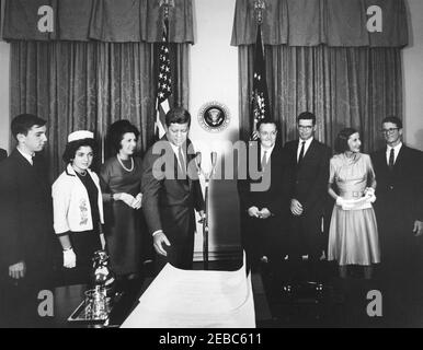 Cerimonia di giuramento, James Ramey u0026 John Palfrey, membri della Commissione per l'energia atomica (AEC), 12:30. Il presidente John F. Kennedy si prepara a presentare i certificati di nomina ai membri della Commissione per l'energia atomica (AEC), James T. Ramey e John G. Palfrey, dopo il loro giuramento. Da sinistra a destra: James N. Ramey; Drucilla Ramey; Dr. Estelle R. Ramey; Presidente Kennedy; nuovi commissari AEC, James T. Ramey e John G. Palfrey; Clochette Roosevelt Palfrey; John G. u0022Seanu0022 Palfrey, Jr. Cabinet Room, White House, Washington, D.C. Foto Stock