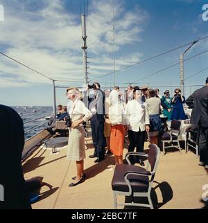 Il presidente Kennedy si accuda alla prima gara di Coppa Americau0027s. Il presidente John F. Kennedy (seduto a sinistra, in background) guarda la prima gara della Coppa Americau0027s 1962 a bordo della USS Joseph P. Kennedy, Jr. Anche nella foto: Il senatore Benjamin A. Smith II (Massachusetts); Nuala Pell, moglie del senatore Claiborne Pell (Rhode Island); John Forbes Kerry; Franklin D. Roosevelt, Jr.; Capo del protocollo, Angier Biddle Duca. Newport, Rhode Island. Foto Stock