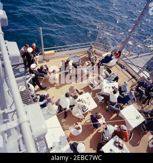 Il presidente Kennedy si accuda alla prima gara di Coppa Americau0027s. Il presidente John F. Kennedy e la First Lady Jacqueline Kennedy partecipano alla prima gara della Americau0027s Cup 1962 a bordo della USS Joseph P. Kennedy, Jr., al largo della costa di Newport, Rhode Island. Il presidente Kennedy (seduto sullo sfondo centrale, guardando attraverso il binocolo) guarda la corsa; la signora Kennedy (seduta a sinistra) visita con il capo del protocollo, Angier Biddle Duke. Anche nella foto: Naval Aide al Presidente, Capitano Tazewell Shepard; Vice Segretario del Tesoro, James A. Reed; sotto Segretario della Marina, Paul u0022Redu0022 fa Foto Stock