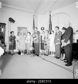 Visita dei volontari del corpo della Pace anziano, 12:30. Il presidente John F. Kennedy (ai microfoni) commenta durante una visita di volontari del corpo della Pace anziano, tra i 60 e i 76 anni, nella Sala dei Pesce della Casa Bianca, Washington, D.C. i volontari presenti includono: Beulah Bartlett; Gertrude Becker; Ralph Cole; Frances R. Cunha; William Darracott; Blythe Monroe; Melissa Moore; Cora Parrish; Alfred Pond; Lina Walden; Barbara Wiggins; Chester Wiggins. [Fotografia di Harold Sellers] Foto Stock