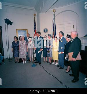 Visita dei volontari del corpo della Pace anziano, 12:30. Il presidente John F. Kennedy (ai microfoni) commenta durante una visita di volontari del corpo della Pace anziano, tra i 60 e i 76 anni, nella Sala dei Pesce della Casa Bianca, Washington, D.C. i volontari presenti includono: Beulah Bartlett; Gertrude Becker; Ralph Cole; Frances R. Cunha; William Darracott; Blythe Monroe; Melissa Moore; Cora Parrish; Alfred Pond; Lina Walden; Barbara Wiggins; Chester Wiggins. Foto Stock