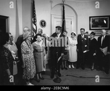 Visita dei volontari del corpo della Pace anziano, 12:30. Il presidente John F. Kennedy (ai microfoni) commenta durante una visita di volontari del corpo della Pace anziano, tra i 60 e i 76 anni, nella Sala dei Pesce della Casa Bianca, Washington, D.C. i volontari presenti includono: Beulah Bartlett; Gertrude Becker; Ralph Cole; Frances R. Cunha; William Darracott; Blythe Monroe; Melissa Moore; Cora Parrish; Alfred Pond; Lina Walden; Barbara Wiggins; Chester Wiggins. Foto Stock