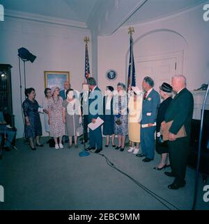 Visita dei volontari del corpo della Pace anziano, 12:30. Il presidente John F. Kennedy (ai microfoni, rivolti in avanti) visita con un gruppo di volontari anziani del corpo della Pace, tra i 60 e i 76 anni, nella Sala dei Pesce della Casa Bianca, Washington, D.C. i volontari presenti includono: Beulah Bartlett; Gertrude Becker; Ralph Cole; Frances R. Cunha; William Darracott; Blythe Monroe; Melissa Moore; Cora Parrish; Alfred Pond; Lina Walden; Barbara Wiggins; Chester Wiggins. Foto Stock