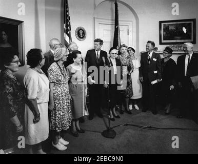 Visita dei volontari del corpo della Pace anziano, 12:30. Il presidente John F. Kennedy (ai microfoni) visita con un gruppo di volontari anziani del corpo della Pace, tra i 60 e i 76 anni, nella Sala dei Pesce della Casa Bianca, Washington, D.C. i volontari presenti includono: Beulah Bartlett; Gertrude Becker; Ralph Cole; Frances R. Cunha; William Darracott; Blythe Monroe; Melissa Moore; Cora Parrish; Alfred Pond; Lina Walden; Barbara Wiggins; Chester Wiggins. Foto Stock