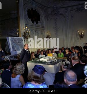 First Lady vede il modello del Centro Culturale Nazionale di Newport, Rhode Island. L'architetto, Edward Durell Stone, parla alla presentazione di un modello architettonico del Centro Culturale Nazionale in una cerimonia presso il palazzo Elms a Newport, Rhode Island; First Lady Jacqueline Kennedy (vestita gialla) si trova in prima fila dietro il modello. I posti a sedere dietro il modello includono anche: Attrice, Geraldine Page; intrattenitore, Danny Kaye; presidente del Washington Area Campaign Committee per il Centro Culturale Nazionale, Janet Auchincloss; direttore musicale della Boston Symphony Orchestra, Erich Foto Stock