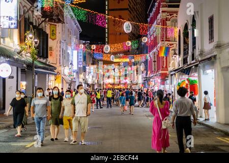 Le persone che indossano il facemask come precauzione contro la diffusione del covid-19 camminare lungo la strada più tranquilla di Chinatown durante la vigilia del Lunar New Year.Singapore è entrato fase 3 il 28 dicembre 2020, consentendo alle persone in gruppi di 8 di incontrarsi per incontri sociali. Foto Stock