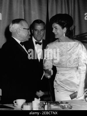 Primo saluto inaugurale alla cena del Presidente, Washington, D.C., Armeria della Guardia Nazionale, 18:45. La First Lady Jacqueline Kennedy saluta l'ex presidente Harry S. Truman durante il primo saluto inaugurale alla cena del presidente in commemorazione dell'anniversario dell'inaugurazione del presidente John F. Kennedyu2019. Un ospite non identificato guarda sopra. National Guard Armory, Washington, D.C. Foto Stock