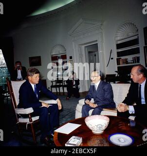 Incontro con l'Ambasciatore di Cina, Dott. Tingfu F. Tsiang, ORE 12:05. Il presidente John F. Kennedy (in sedia a dondolo) incontra il neo nominato ambasciatore cinese negli Stati Uniti, Tingfu F. Tsiang. Il capo del protocollo degli Stati Uniti Angier Biddle Duke si siede a destra; i fotografi osservano. Foto Stock