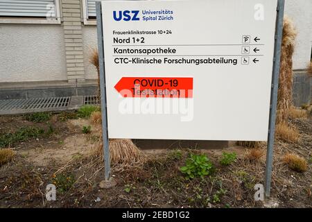 Cartello dell'Ospedale Universitario di Zurigo che mostra le indicazioni in lingua tedesca e un cartello con la forma di una freccia per il centro o stazione di test covid-19. Foto Stock