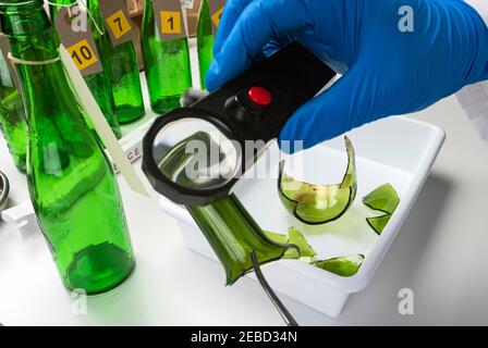 Esperto di polizia diventa campione di sangue dalla bottiglia di vetro in Criminalistic Lab Foto Stock