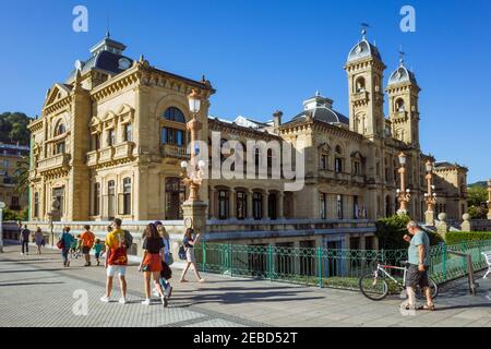 San Sebastian, Gipuzkoa, Paesi Baschi, Spagna - 15 luglio 2019 : la gente cammina oltre il municipio di San Sebastian originariamente costruito nel 1887 per ospitare il Foto Stock