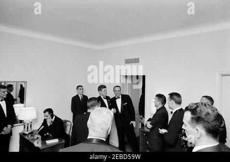 Football Hall of Fame Dinner, New York City, 10:00. Il presidente John F. Kennedy visita con i partecipanti alla cena della Football Hall of Fame. L-R: Quarterback dell'Università dell'Alabama, Pat Trammel; Presidente dell'Università dell'Alabama, Dr. Frank Rose (parlando al telefono); membro dello staff dell'Agenzia di segnalazione dell'Esercito della Casa Bianca (WHASA), John J. Cochran; uomo d'affari dell'Alabama, Tom Russell (in primo piano, di ritorno alla telecamera); Segretario della stampa Pierre Salinger (di fronte a Russell, Presidente Kennedy; Sportscaster, Mel Allen; Birmingham News sport scrittore, Benny Marshall; Università di Alabama sport Hall of Foto Stock