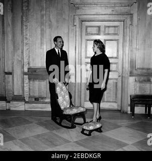 Sedia a dondolo donata alla Casa Bianca. Sedia a dondolo con poggiapiedi donata alla Casa Bianca da Memphis, Tennessee, Camera di Commercio Junior. Due membri dello staff della Casa Bianca non identificati. La lobby dell'Ala Est, la Casa Bianca, Washington, D.C. Foto Stock