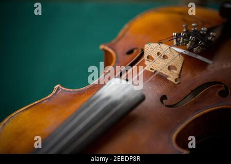 Primo piano di archi di violino con sfondo verde Foto Stock