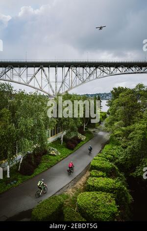 Vista aerea dei ciclisti sulla pista ciclabile urbana con ponte in distanza Foto Stock