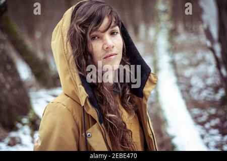 Giovane donna con capelli ricci e lunghi in inverno giacca da neve Foto Stock