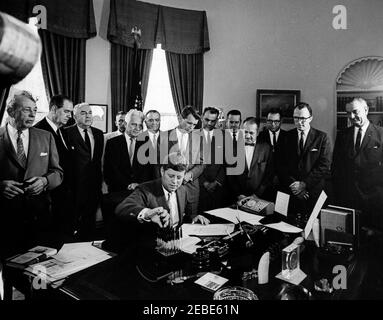 Bill Signings u2013 S. 1653, S. 1656, S. 1657, Interstate Anti-Crime Acts, 11:00AM. Il presidente John F. Kennedy firma S. 1656, S. 1657, e S. 1653 (legge contro la criminalità organizzata e il racketeering) nell'Oval Office, White House, Washington, D.C. guardando (L-R): Il senatore Everett Dirksen dell'Illinois; il senatore Olin Johnston della Carolina del Sud; il senatore Sam Ervin della Carolina del Nord; Capo della Sezione criminalità organizzata del Dipartimento di Giustizia, Edwyn Silberling (parzialmente nascosto); Senatore Kenneth Keating di New York; Direttore del Federal Bureau of Investigation (FBI), J. Edgar Hoover; Attorn Foto Stock