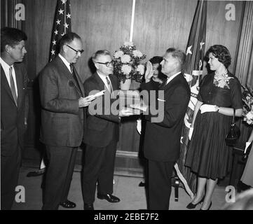 Cerimonia di giuramento, James J. Rowley, Direttore del Servizio Segreto, 10:37. I partecipanti e gli ospiti assistono alla cerimonia di giuramento per il nuovo direttore del servizio segreto James J. Rowley presso il Dipartimento del Tesoro di Washington, D.C. (L-R) il presidente John F. Kennedy; il segretario del Tesoro C. Douglas Dillon; l'impiegato non identificato; la moglie del direttore Rawleyu2019s Mabel Rita Cluen Rowley; il direttore Rowley; il direttore Rawleyu2019s figlia Claudia Rowley. [Fotografia di Harold Sellers] [il cerchio scuro sull'immagine è originale al negativo.] Foto Stock
