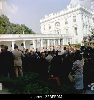 Visita del 1 ° corpo di Pace Volontarii per andare all'estero, 16:10. Il presidente John F. Kennedy è circondato da volontari del corpo della Pace durante una cerimonia per il primo gruppo di volontari in partenza, in partenza per Tanganyika e Ghana, nel Rose Garden, Casa Bianca, Washington, D.C. i giornalisti e i fotografi osservano. [Per un elenco completo dei partecipanti, vedere White House Central Subject Files, Box 670, Folder 1: U0022PC 5 Peace Corps Program (Executive, 1-20-61 - 4-10-62).u0022] Foto Stock