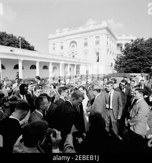 Visita del 1 ° corpo di Pace Volontarii per andare all'estero, 16:10. Il presidente John F. Kennedy è circondato da volontari del corpo della Pace durante una cerimonia per il primo gruppo di volontari in partenza, in partenza per Tanganyika e Ghana, nel Rose Garden, Casa Bianca, Washington, D.C. i giornalisti e i fotografi osservano. [Per un elenco completo dei partecipanti, vedere White House Central Subject Files, Box 670, Folder 1: U0022PC 5 Peace Corps Program (Executive, 1-20-61 - 4-10-62).u0022] Foto Stock