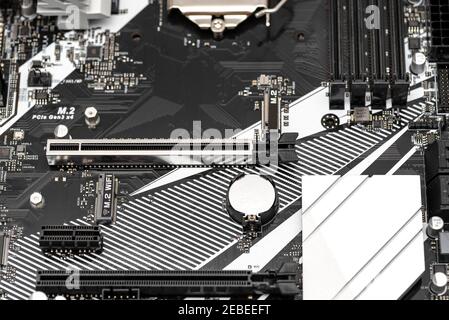 Una moderna scheda madre di un computer desktop di colore nero con connettore PCI Express visibile, batteria e dissipatori di calore. Foto Stock