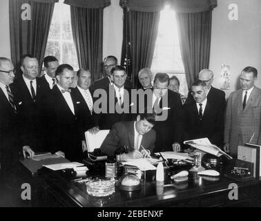 Bill Signing u2013 S-610 Act istituting the US Travel Service, 12:15. Il presidente John F. Kennedy firma la S-610 Act, che istituisce il servizio di viaggio degli Stati Uniti all'interno del Dipartimento del Commercio. (L-R) uomo non identificato, membro del Congresso Robert W. Hemphill (Carolina del Sud), uomo non identificato, membro del Congresso Peter F. Mack (Illinois), membro del Congresso Milton W. Glenn (New Jersey), membro del Congresso John B. Bennett (Michigan), membro del Congresso Oren Harris (Arkansas), presidente Kennedy, uomo non identificato (dietro), senatore Warren, G. Magnuson (Washington) Presidente della Commissione europea dei viaggi Manolita T. Doelger Foto Stock