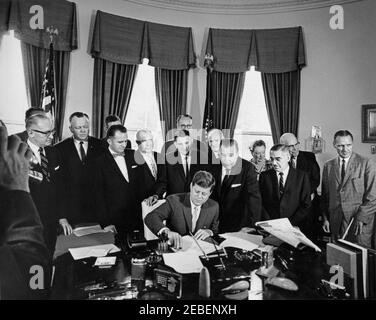 Bill Signing u2013 S-610 Act istituting the US Travel Service, 12:15. Il presidente John F. Kennedy firma la S-610 Act, che istituisce il servizio di viaggio degli Stati Uniti all'interno del Dipartimento del Commercio. (L-R) uomo non identificato, membro del Congresso Robert W. Hemphill (Carolina del Sud), uomo non identificato (sul retro), membro del Congresso Peter F. Mack (Illinois), membro del Congresso Milton W. Glenn (New Jersey), membro del Congresso John B. Bennett (Michigan), membro del Congresso Oren Harris (Arkansas), presidente Kennedy, uomo non identificato (sul retro), Senuson (Washington), Magnuson G. Presidente della Commissione europea dei viaggi Manolita Foto Stock