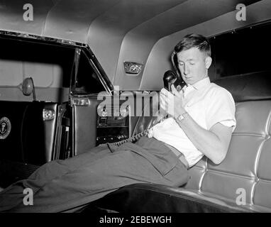 Installazione di attrezzature della White House Army Signal Agency (WHASA) in una nuova limousine. Un membro non identificato del personale della White House Army Signal Agency (WHASA) lavora al telefono nel sedile posteriore durante l'installazione dell'attrezzatura WHASA nella nuova limousine presidenziale Lincoln-Mercury Continental. [Fotografia di Harold Sellers] Foto Stock