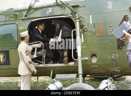 Indirizzo di inizio alla US Naval Academy, Annapolis, Maryland, 11:04. Il presidente John F. Kennedy (indossando occhiali da sole) siede all'interno di un elicottero sul prato sud della Casa Bianca durante il tragitto per la cerimonia di inizio alla United States Naval Academy di Annapolis, Maryland. Foto Stock