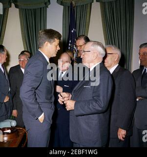 Bill Signing u2013 HR 6518 Public Law 87-41, Inter-American Social and Economic Cooperation Program Act, 9:50. Il presidente John F. Kennedy parla con l'ex presidente Harry S. Truman dopo aver firmato la legge pubblica 87-41, il programma interamericano di cooperazione sociale ed economica e la legge cilena sul programma di ricostruzione e riabilitazione. Altri, L-R: Senatore Hubert H. Humphrey (Minnesota); Congressman Chester E. Merrow (New Hampshire); Congressman John J. Rooney (New York); non identificato; Senatore George D. Aiken (Vermont); non identificato. Ovale Foto Stock