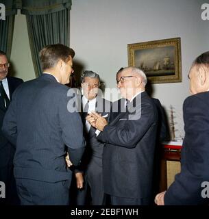 Bill Signing u2013 HR 6518 Public Law 87-41, Inter-American Social and Economic Cooperation Program Act, 9:50. Il presidente John F. Kennedy parla con l'ex presidente Harry S. Truman dopo aver firmato la legge pubblica 87-41, il programma interamericano di cooperazione sociale ed economica e la legge cilena sul programma di ricostruzione e riabilitazione. Molti uomini non identificati guardano sopra. Ufficio ovale, Casa Bianca, Washington, D.C. Foto Stock