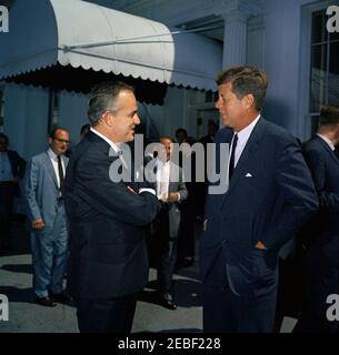 Pranzo in onore del Principe Rainier III e della Principessa Grazia di Monaco, alle 13:00. Il presidente John F. Kennedy parla con il principe Ranier III di Monaco dopo un pranzo in onore del principe e di sua moglie, la principessa Grazia. Le persone non identificate guardano sopra. Ingresso dell'ala ovest, Casa Bianca, Washington, D.C. Foto Stock