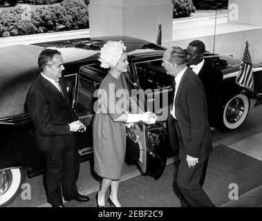 Pranzo in onore del Principe Rainier III e della Principessa Grazia di Monaco, alle 13:00. Arrivo degli ospiti per pranzo in onore del Principe Ranier III e della Principessa Grazia di Monaco (attrice Grace Kelly). L'assistente presidenziale Dave Powers saluta la principessa Grace mentre esce dall'automobile; il principe Ranier si leva in piedi alla sinistra. L'uomo a destra non è identificato. Portico Nord, Casa Bianca, Washington, D.C. Foto Stock