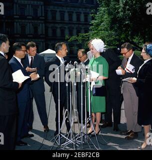 Pranzo in onore del Principe Rainier III e della Principessa Grazia di Monaco, alle 13:00. Il principe Ranier III e la principessa Grace di Monaco (attrice Grace Kelly) parlano ai giornalisti dopo un pranzo in loro onore. I giornalisti osservano, compreso il corrispondente della Casa Bianca per il Columbia Broadcasting System (CBS), George Herman (secondo da destra). All'esterno dell'entrata dell'Ala Ovest, la Casa Bianca, Washington, D.C. Foto Stock