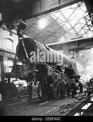 Una prima fotografia da stampa di un motore che viene abbassato su è ruote presso le opere della locomotiva ferroviaria a Doncaster, Inghilterra. Doncaster opere ferroviarie situato nella città di Doncaster, South Yorkshire, Inghilterra. Sostituito un precedente lavori a Boston e Peterborough. Come altre fabbriche, durante la seconda guerra mondiale fu comandeato per realizzare altri oggetti come gli alianti Horsa per l'assalto aereo del D-Day. Il negozio di carrozze fu distrutto da IRE nel 1940, i nuovi edifici costruiti nel 1949 sono stati progettati per adattarsi alla British Railways standard tutte le carrozze in acciaio. La costruzione del treno a vapore è terminata nel 1962. Foto Stock