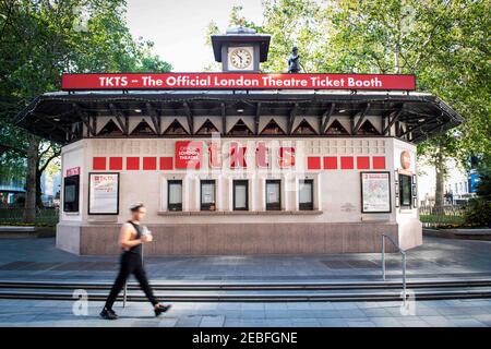 Un membro del pubblico cammina davanti al Ticket Booth ufficiale del Teatro di Londra in Leicester Square, che è chiuso a causa della pandemia di Coronavirus e che difficilmente si aprirà presto a meno che le linee guida del blocco del governo non cambiino, Londra. Data immagine: Giovedì 25 giugno 2020. Il credito fotografico dovrebbe essere: David Jensen Foto Stock