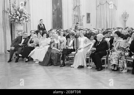 Cena in onore dei vincitori del Premio Nobel, alle 20:00. Il presidente John F. Kennedy e altri si riuniscono nella Sala Est per partecipare a una lettura da parte dell'attore, Frederic March, di brani tratti dalle opere dei vincitori del premio Nobel americano nel corso di una cena in onore dei premi Nobel dell'emisfero occidentale. Seduti in prima fila (L-R): Vice Presidente Lyndon B. Johnson; Katherine Tupper Marshall (vedova del Premio Nobel ed ex Segretario di Stato, Generale George C. Marshall); Lady Bird Johnson; autore vincitore del Premio Nobel Pearl S. Buck; Presidente Kennedy; First Lady Jacqueline Kennedy; poeta e Premio Nobel Foto Stock