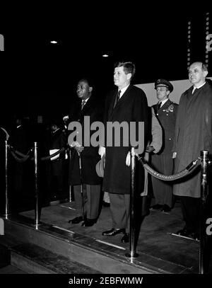 Cerimonia di arrivo per Kwame Nkrumah, presidente del Ghana, 15:43. Il presidente John F. Kennedy partecipa alle cerimonie di arrivo in onore del presidente della Repubblica del Ghana, Osagyefo Dr. Kwame Nkrumah. Sulla piattaforma (L-R): Presidente Nkrumah; Presidente Kennedy; Presidente dei Capi di Stato congiunti, Generale Lyman Lemnitzer; Segretario di Stato, Dean Rusk. Anche nella foto: Segretario alla stampa associato, Andrew Hatcher (a sinistra, rivolto verso la parte opposta). Hangar n. 10, Terminal del Servizio militare di trasporto aereo (MATS), Aeroporto Nazionale di Washington, Washington, D.C. Foto Stock