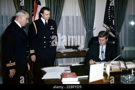 Cerimonia di ritiro per il Lt. Charles J. Langello, Ufficio dell'Aide Navale. Il presidente John F. Kennedy incontra il suo assistente in pensione presso l'Aide Navale al presidente tenente Charles J. Langello presso l'Ufficio ovale della Casa Bianca, Washington, D.C.. (L-R) il tenente Langello; Naval Aide al presidente Tazewell Shepard, Jr.; il presidente Kennedy. Foto Stock